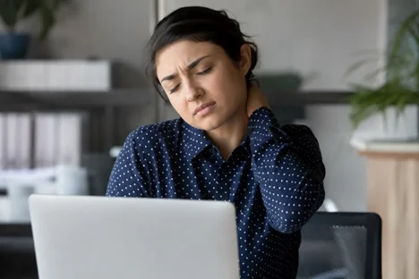 Office worker with neck pain from poor posture needing professional massage therapy | Sommnest