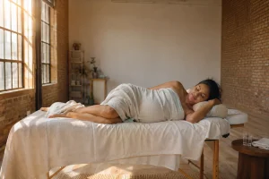 A pregnant woman resting comfortably on her side during a prenatal massage benefits session.